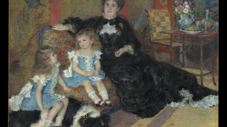 Woman seated with two children and a dog indoors