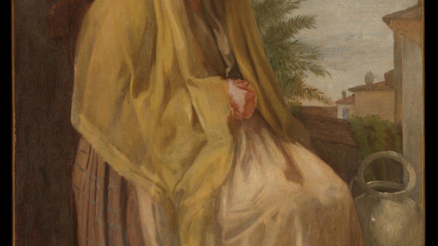 Elderly woman seated with shawl outdoors